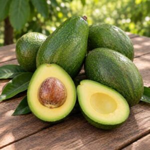 Aguacates Bacon ecológicos, enteros y abiertos por la mitad, sobre una mesa de madera